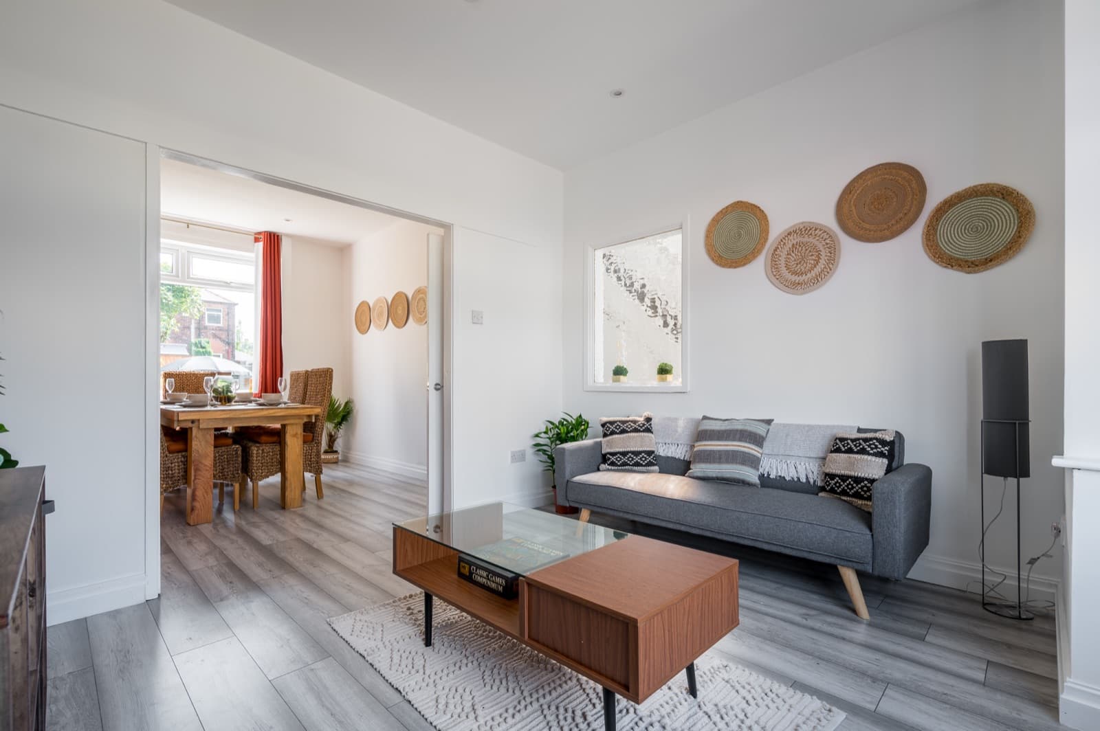 A warm living room opening onto a dining room with a set table